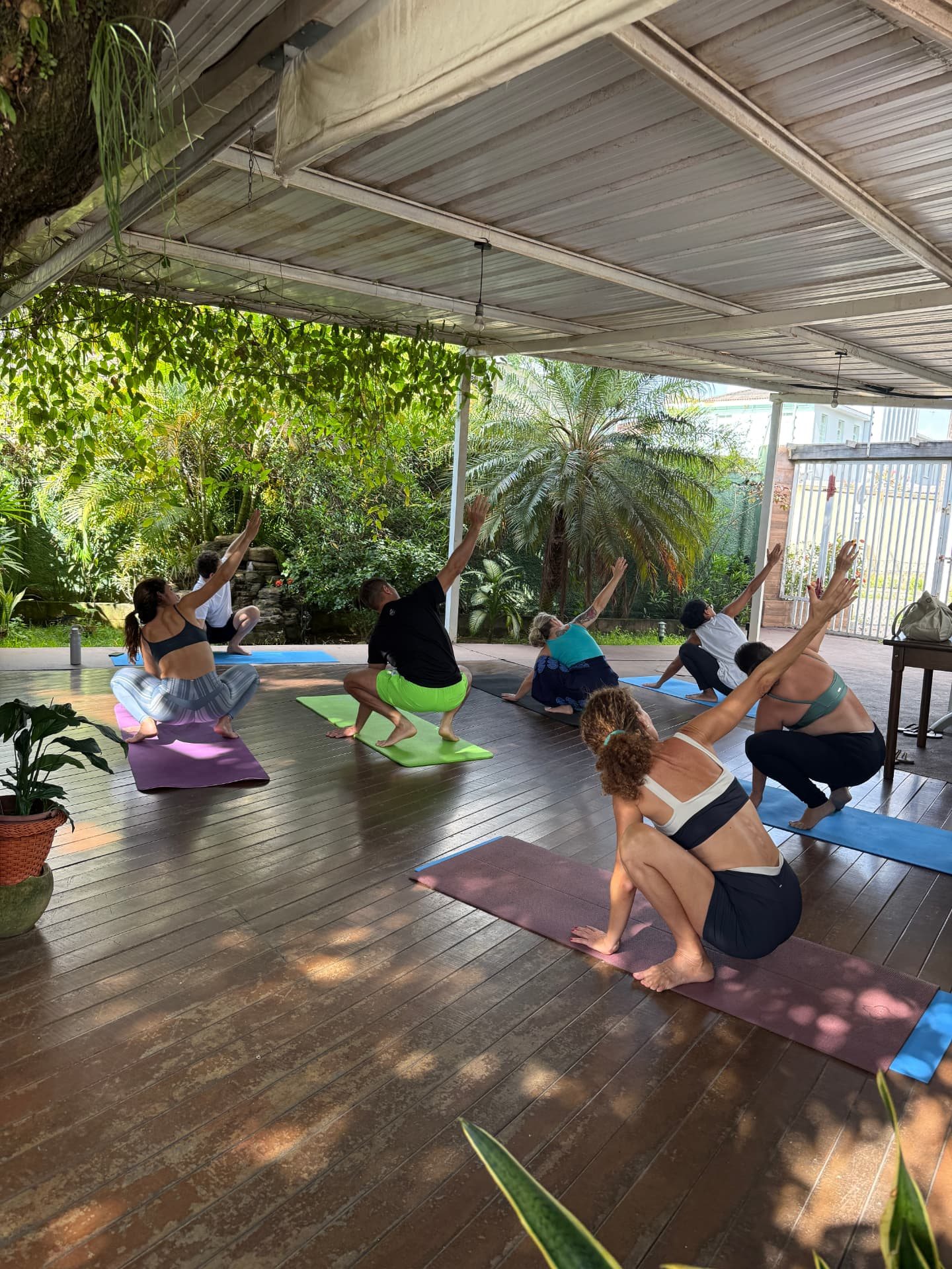 Prática de Yoga no deck de madeira do Marzen, cercado por plantas